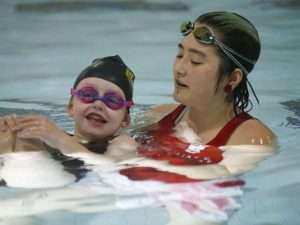 A photo of Madi swimming with instructor, Tab Enta. T