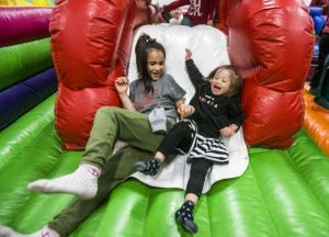 A photo of Emalee and her sister Maya sliding down an inflatable obstacle course.