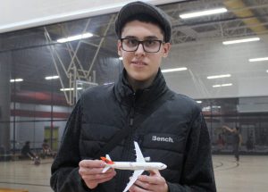 A photo of Quentin smiling holding an model airplane