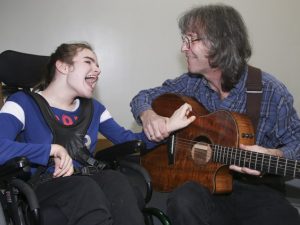 Chris McHardy plays his guitar for his daughter Kathleen at Variety Village on Friday December 17, 2021