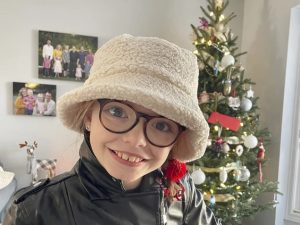 Madi wearing a cream coloured sherpa bucket hat smiling 