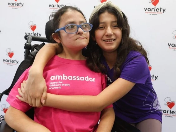 A sisterly hug: Variety Village ambassadors, Maya Salas Martinez ,11, (in purple), with her sister Amanda Salas Martinez, 16, (in pink)