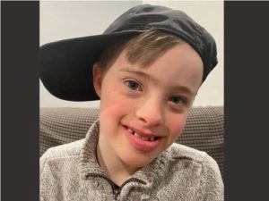 a young boy wearing a hat smiling