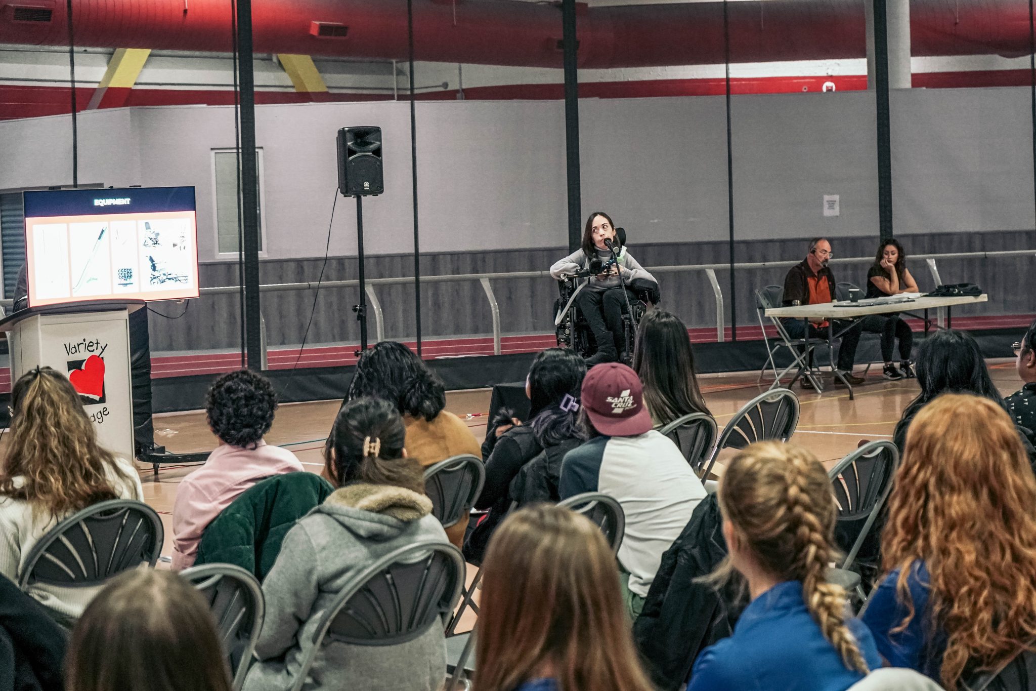 A conference speaker on a wheelchair in front of a huge crowd
