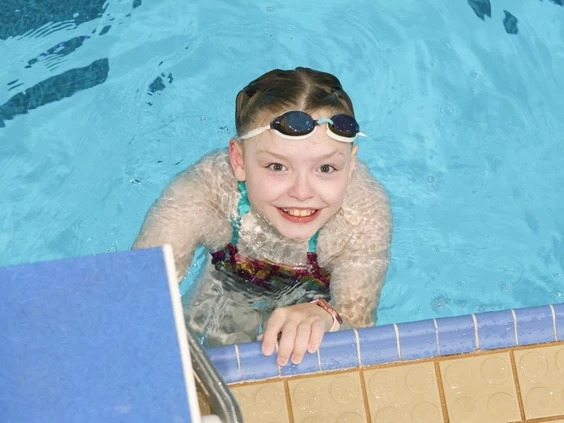 A young girl (Madi) swimming in the pool